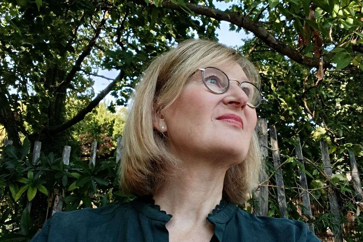 Marie-Eve Cassal, fondatrice de CAP SATORI, le regard tourné vers le haut dans un cadre arboré.